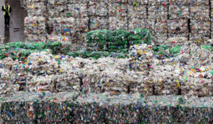 LONDON - MARCH 25:  An employee of the 'Closed Loop Recycling' plant walks past stacks of plastic bottles at their plant in Dagenham on March 25, 2010 in London, United Kingdom. The state of the art plant is the first in the UK to produce food grade recycled plastic from bottle waste. Over 35,00 tonnes of plastic bottles are recycled at the plant annually, representing almost 20% of the plastic bottles currently collected for recycling in the UK, and saving approximately 52,500 tonnes of carbon dioxide per year.  (Photo by Dan Kitwood/Getty Images)